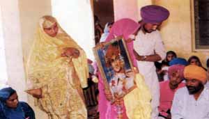 Bibi Surinder Kaur taking laavan with photo of Shaheed Bhai Satwant Singh